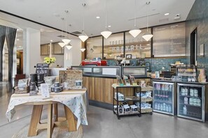 En kaffebutiks interiör med en disk, kaffemaskiner och en menytavla.