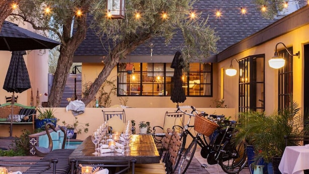 An outdoor dining area with tables, chairs, string lights, and a bicycle. - HeatedPool, Upscale in OldTown Scottsdale (Scottsdale)