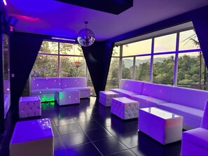 En moderne lounge med sofa, skammel og en diskokugle.