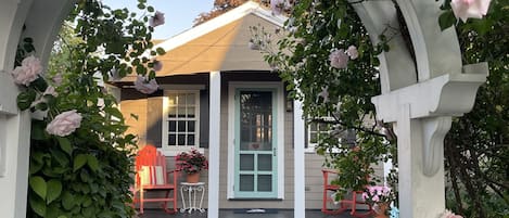 A house with a porch, a white picket fence, and a pathway leading to the entrance.