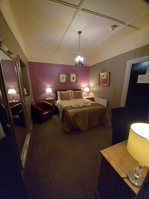 A hotel room with a bed, bedside lamps, a desk, and a chair. - No 1 Hotel (Wooler)