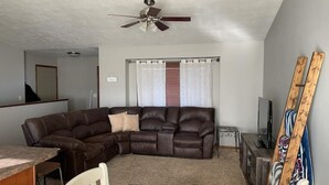 A living room with a sectional sofa, a dining table, and a ceiling fan. - Cozy ranch style house in a quiet neighborhood (Sioux Falls)