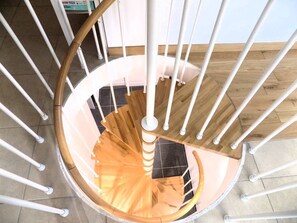 A spiral staircase with white railings and wooden steps.