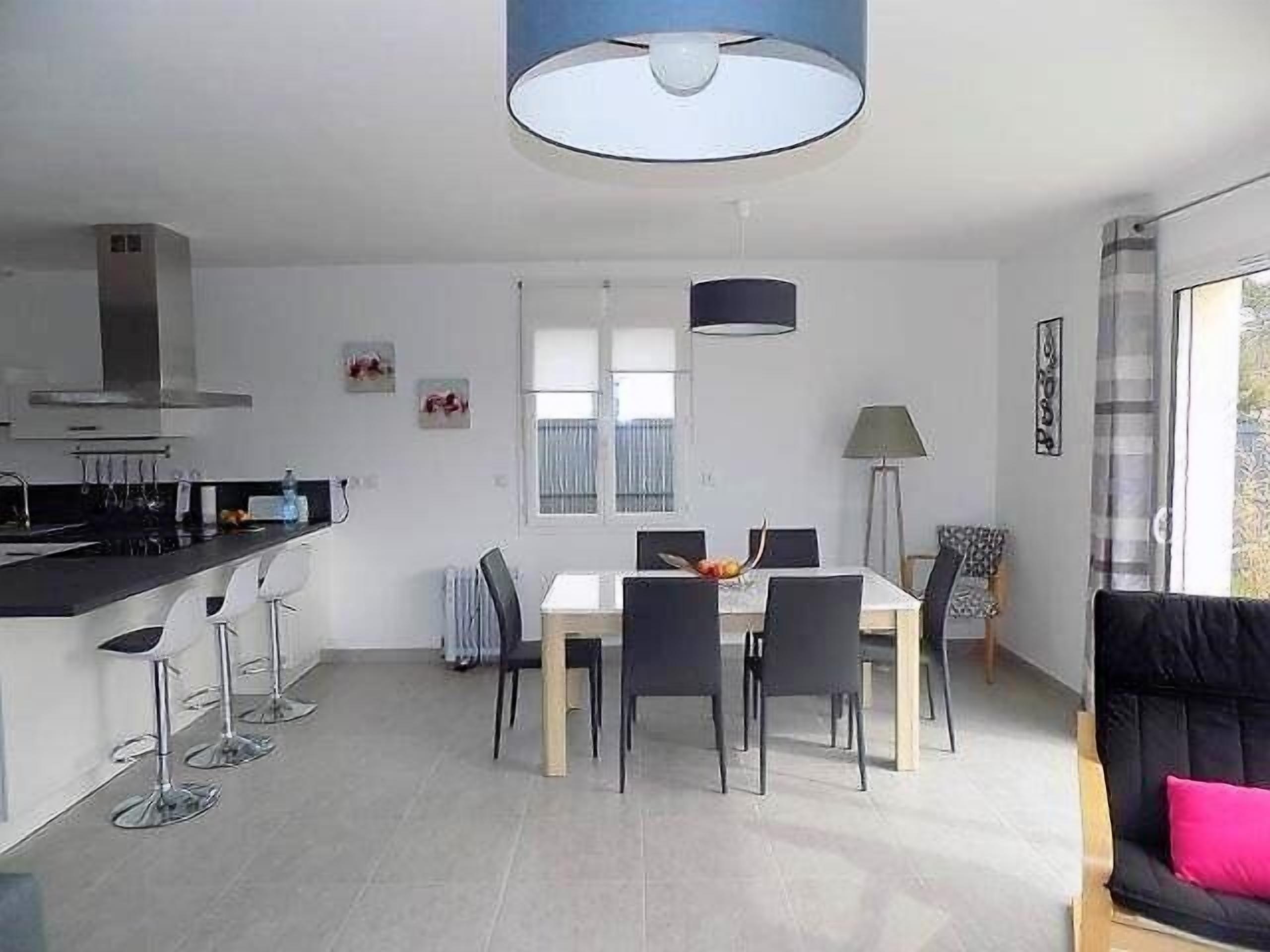 Eine moderne Küche mit Essbereich, einer Couch und einem großen Fenster.