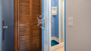 A bathroom with a shower, a wooden door, and a tiled wall. - AS21387-Studio cabin and private parking 200m sea (LE GRAU DU ROI)