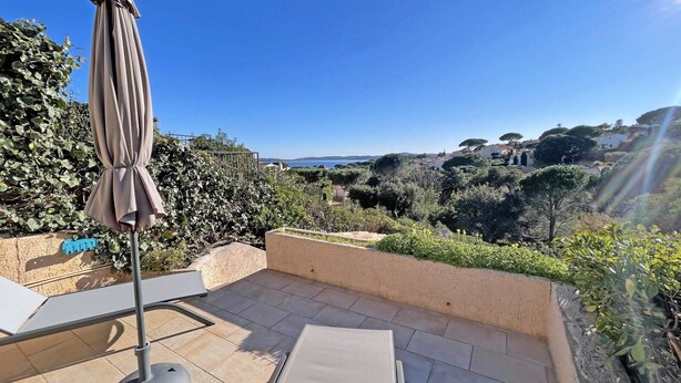 A patio with a table and an umbrella, overlooking a scenic landscape with trees and buildings. - House for 4 people - Sea view - Swimming pool - Air conditioning - WiFi - Near beach - Sainte Maxime (STE MAXIME)