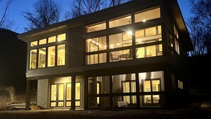 A modern two-story building with large windows and a balcony.