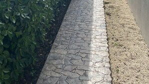 Un sendero que lleva a un edificio con fachada azul y varias ventanas.