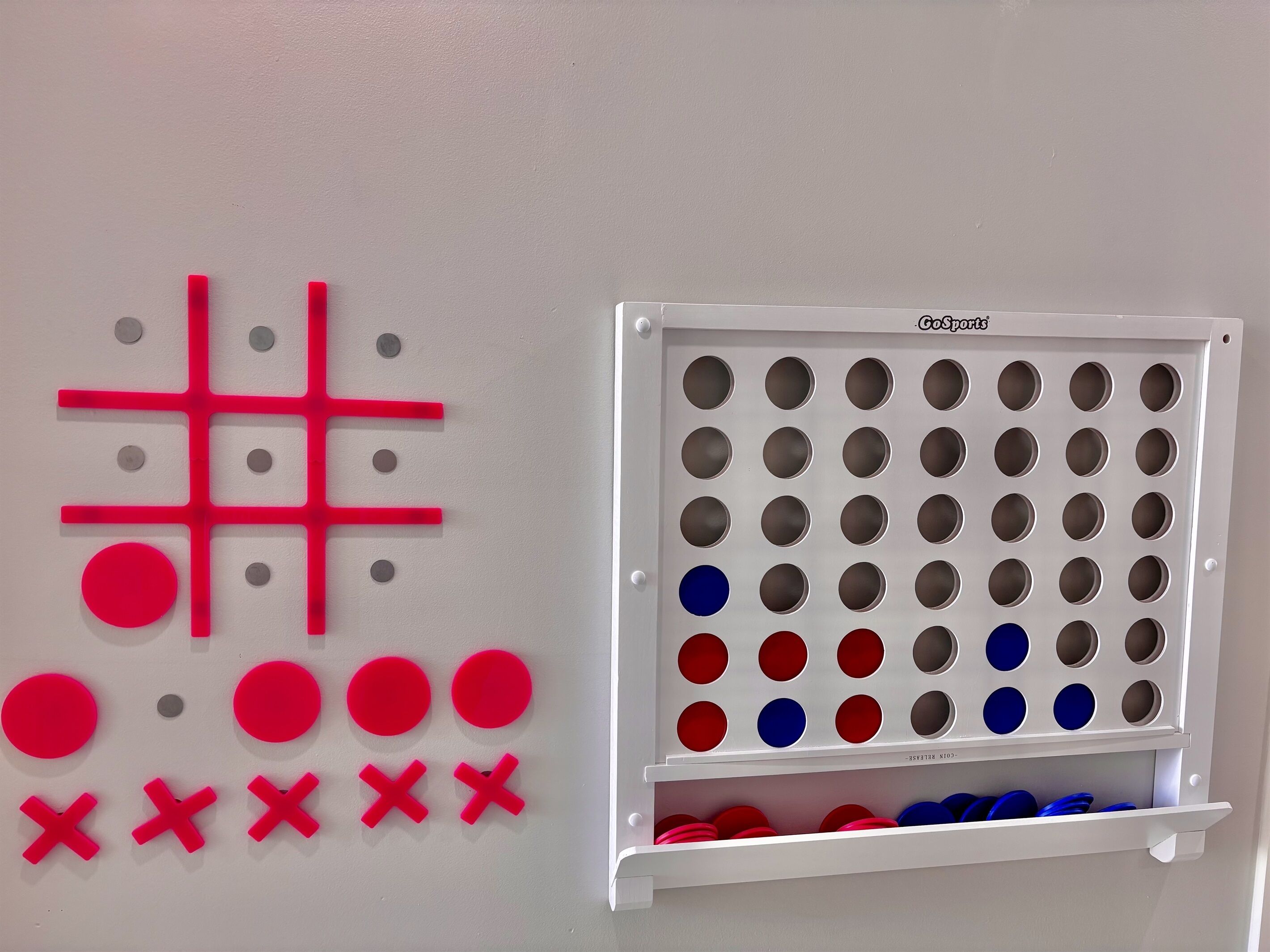 A wall with a pegboard and a storage unit with multiple compartments.