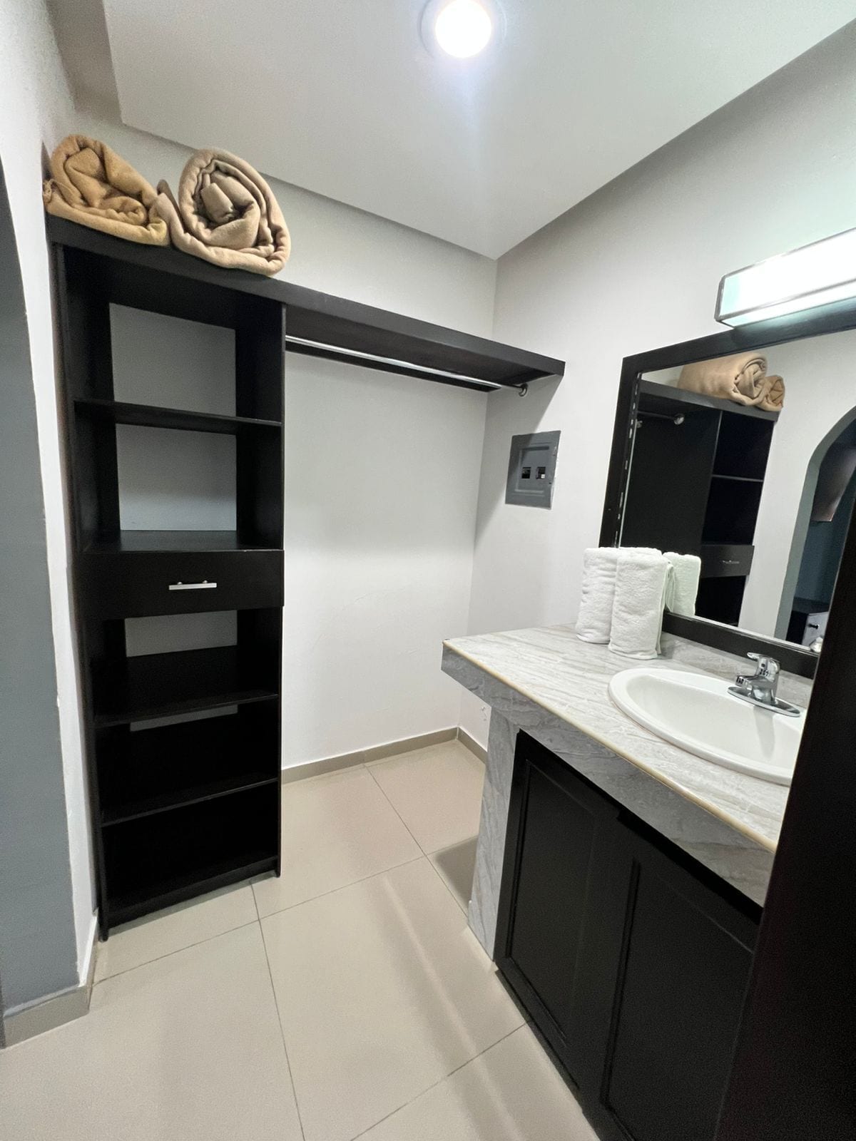 A modern bathroom with a built-in shelf, a sink, and a mirror.