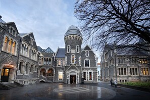 A large, historic building with a central tower and multiple wings, featuring arched windows and a grand entrance. - The Observatory Hotel Christchurch (Christchurch)