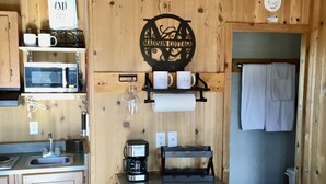 A compact kitchen with wooden walls, a microwave, a coffee maker, and a sink. - Tiny Cottages in Cloudcroft/ Mayhill  NM (Mayhill)