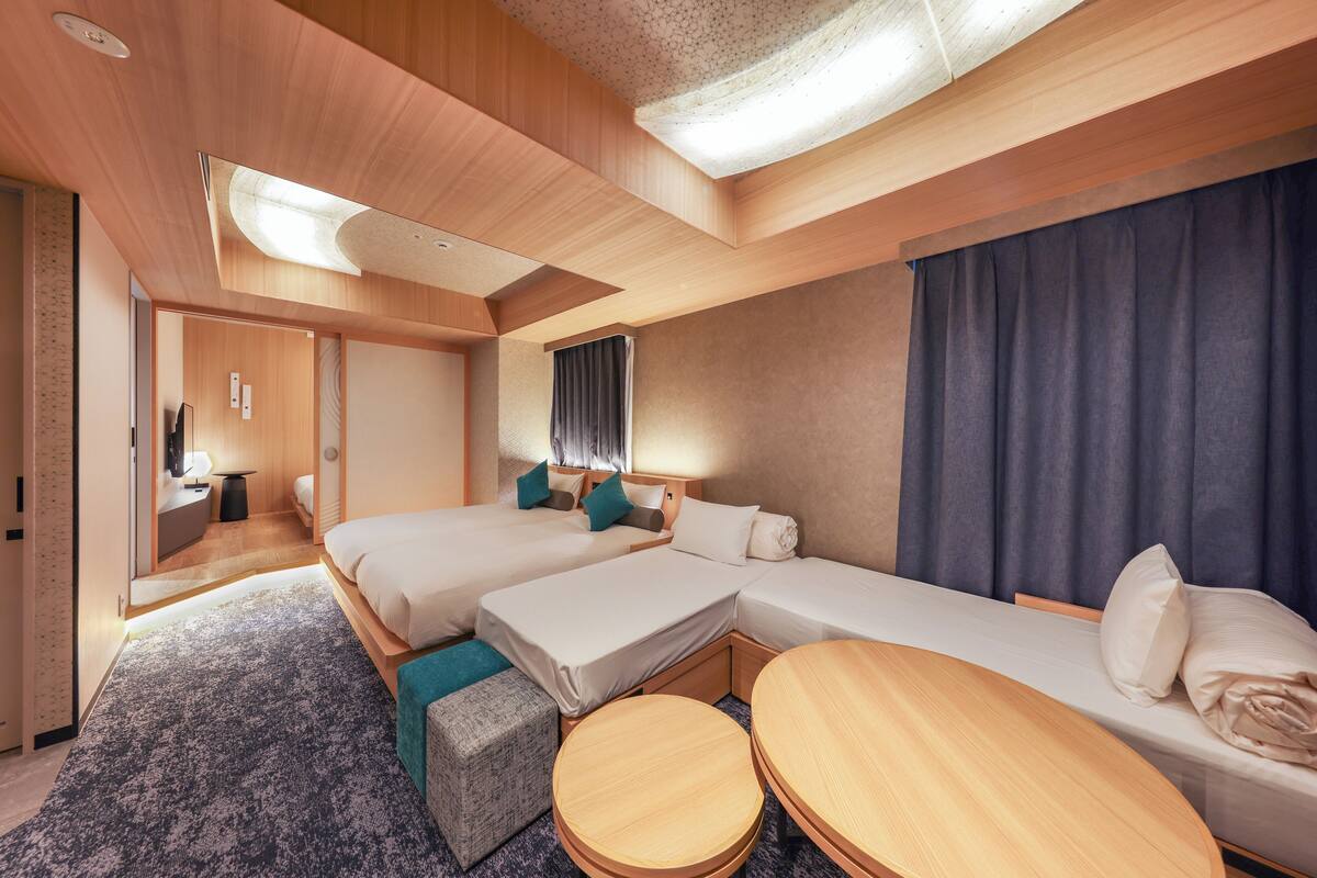 Een moderne hotelkamer met twee bedden, een tafeltje en een bank.