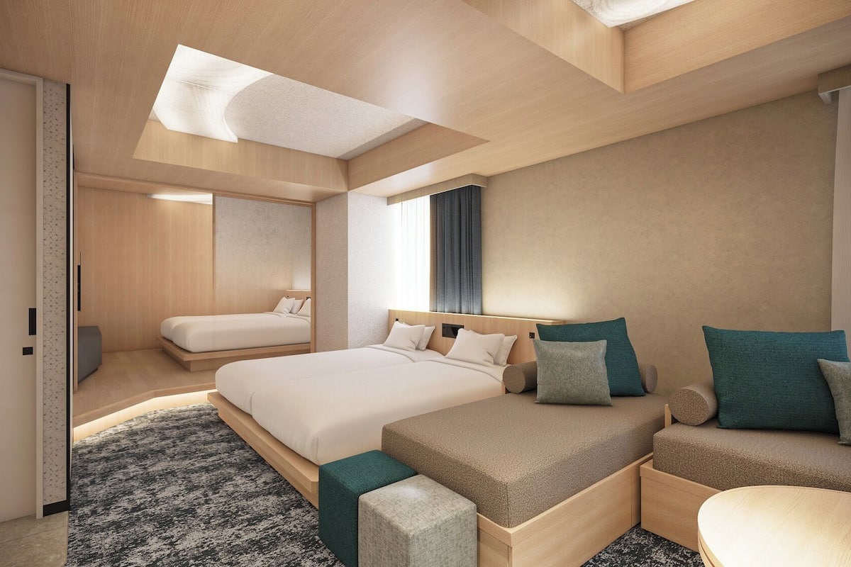 Een moderne hotelkamer met een groot bed, een sofa en een bureau.