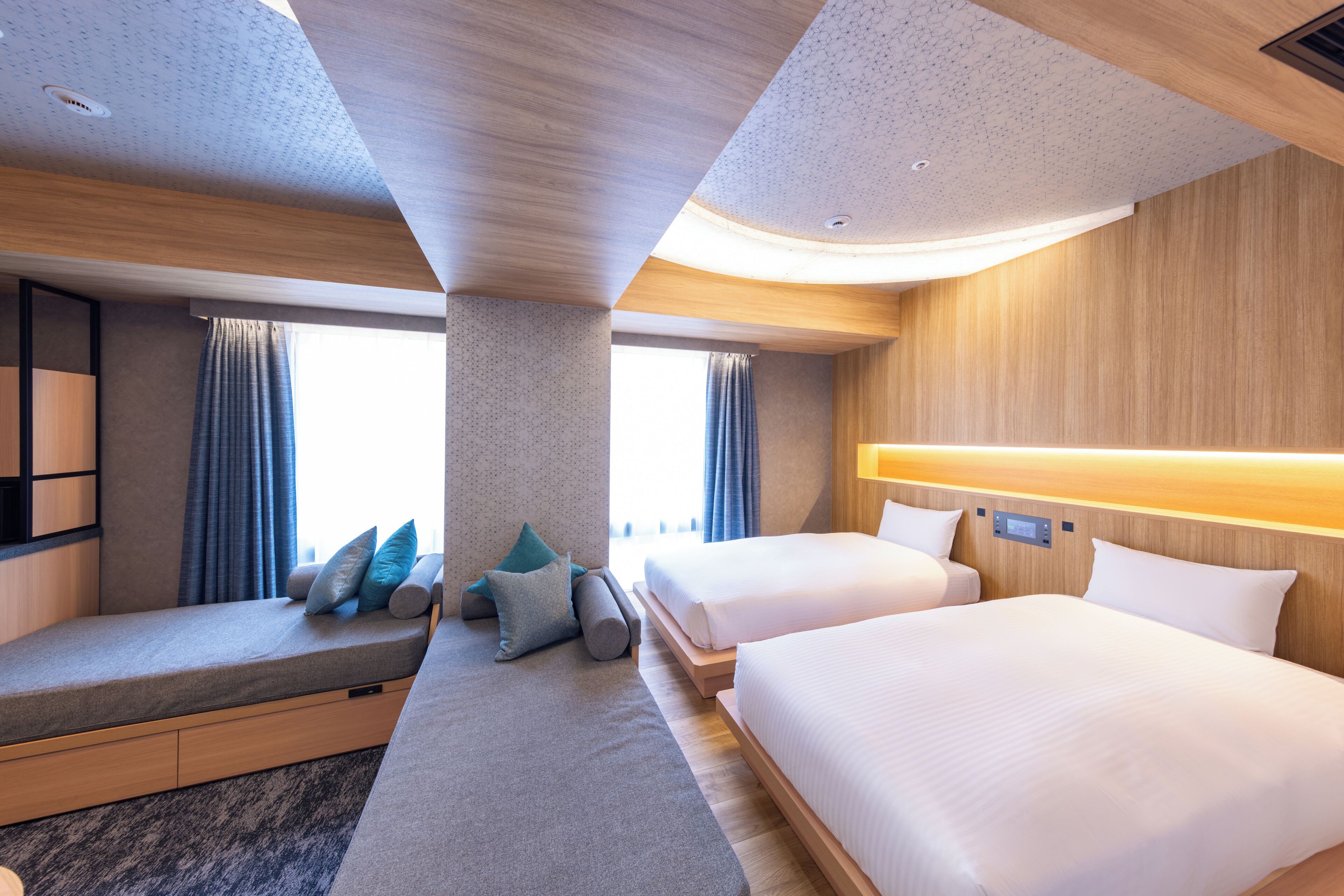A hotel room with a bed, a sofa, a desk, and a window.