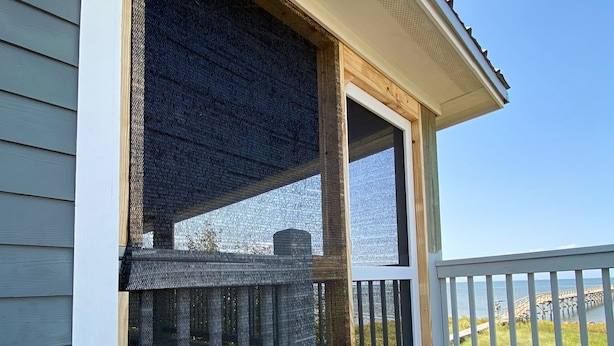 A wooden deck with a railing, a window with a mesh screen, and a view of a pier and water. - Waterfront!! Private Pier! Reel Relaxing, Real Fun On Sabine Lake (Port Arthur)
