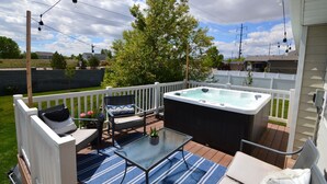 A backyard with a hot tub, outdoor furniture, and a glass table. - Amazing 3 Bedrooms / 2 Bathrooms home with PRIVATE HOT TUB!!! (West Jordan)