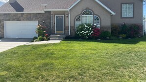 A two-story house with a stone facade, a garage, and a well-maintained lawn. - Amazing 3 Bedrooms / 2 Bathrooms home with PRIVATE HOT TUB!!! (West Jordan)