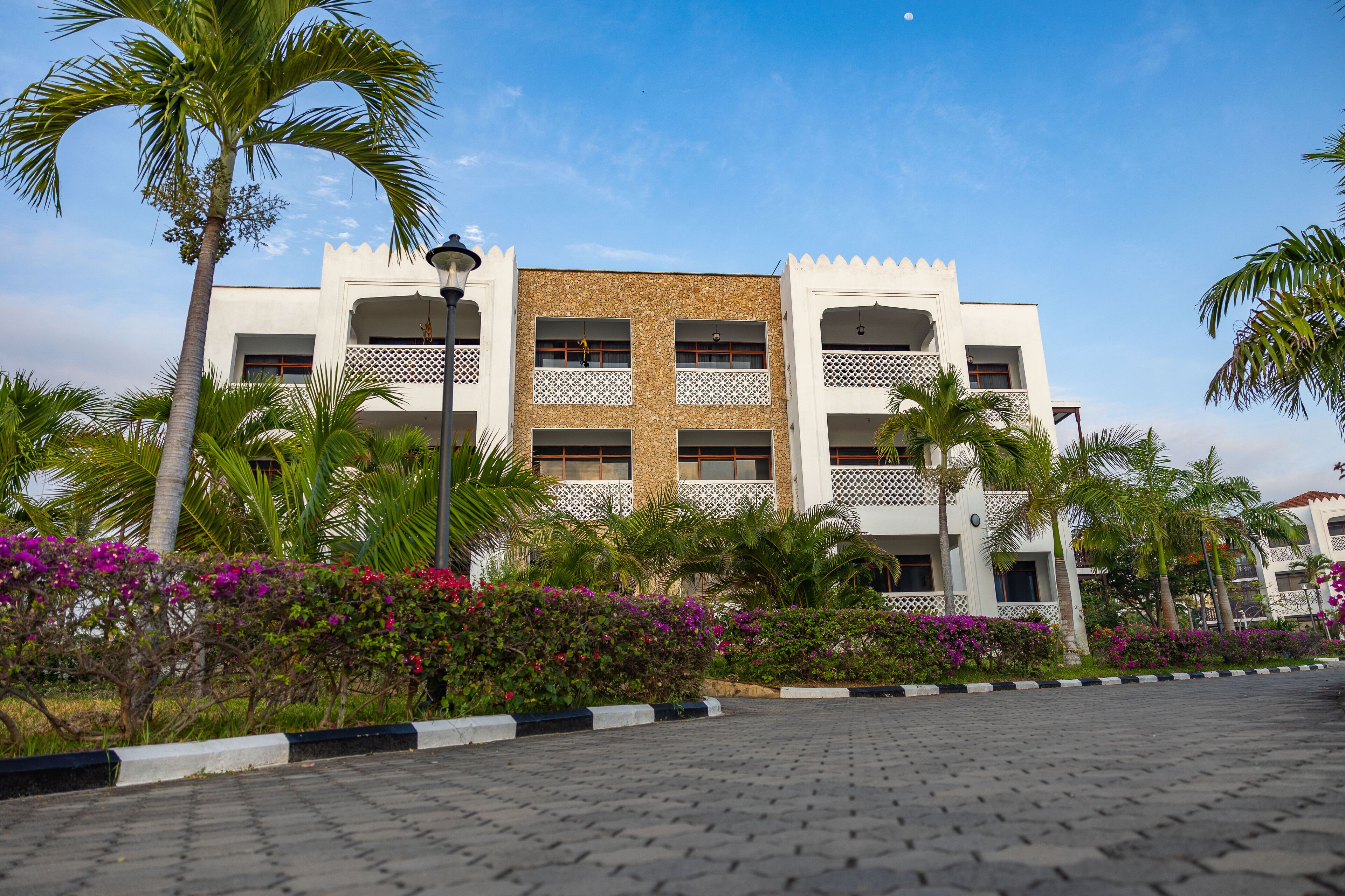 A multi-story building with a white facade and a central courtyard.