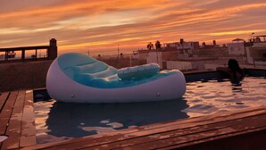 An inflatable pool with a view of a sunset over a cityscape.