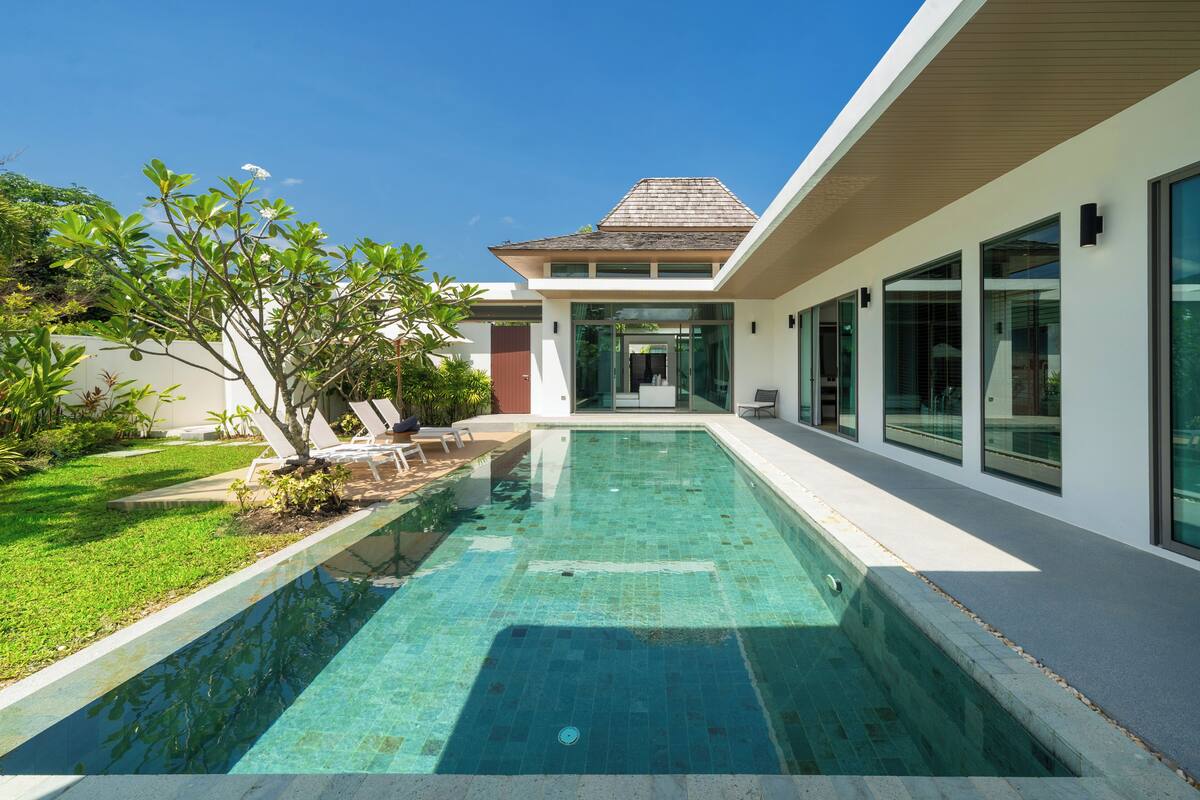 A modern house with a swimming pool, a covered patio, and a well-maintained garden.