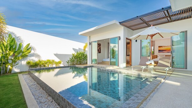 Una casa moderna con piscina, un patio cubierto y vistas del atardecer.