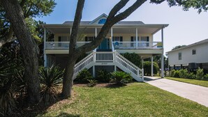 A two-story house with a covered porch and a staircase leading to the second floor.