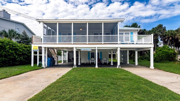 A two-story building with a covered porch and a balcony.