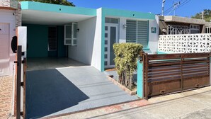 A two-story building with a covered entrance and a gated driveway. - Lucor D- Eight House (Rincon PR)