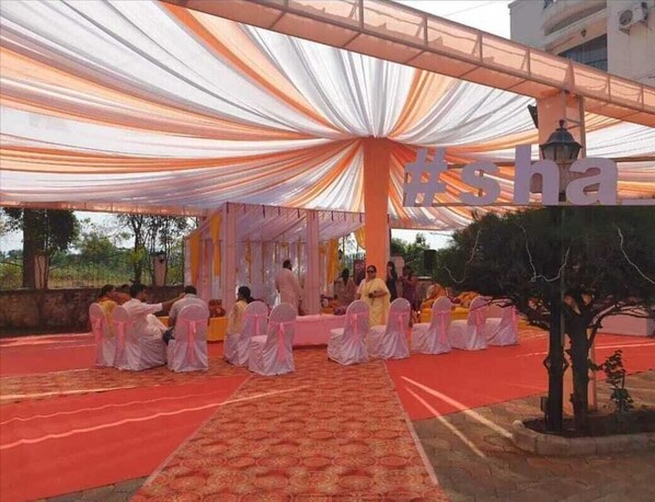 Event space with a stage, draped fabric, and a low wall, perfect for gatherings and performances.