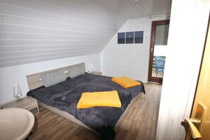Ein Schlafzimmer mit einem Bett, Nachttischen und Blick ins Freie.