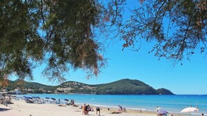 A beach with people sunbathing, umbrellas, and a clear view of the sea and hills in the background. - L'Italienne by Interhome (Saint Cyr sur mer Les Lecques)