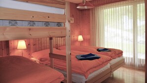 A room with two bunk beds, wooden walls, a window with sheer curtains, and a hanging lamp. - Nice flat for rent in les Collons (Thyon-Les Collons)