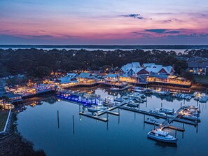 A waterfront marina with docked boats and a row of buildings with multiple levels and outdoor seating areas. - Sea Pines Cottage •Sleeps 10 •Close to Trails & Beach •Bike Everywhere (Hilton Head Island)