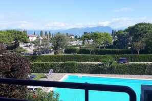 Un espace piscine offrant une vue dégagée sur le paysage environnant, notamment sur les arbres et les montagnes au loin.