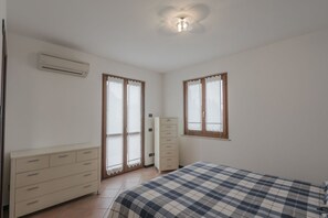 Ein Schlafzimmer mit einem Bett, einem Schminktisch, einem Kleiderschrank und zwei Vorhängen.
