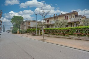 Una calle residencial con casas, un banco y cielo despejado.
