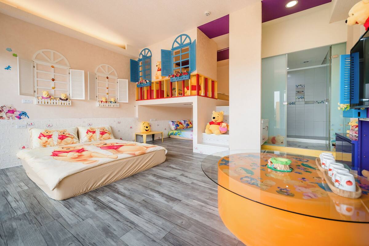 A children's room with a bed, a play area, and a glass shower.