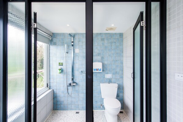 A bathroom with a shower, toilet, and a window. - Happiness Pink B&B (Liuqiu)