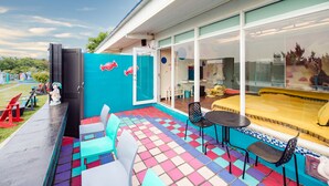 A colorful outdoor patio with a pool, seating area, and a view of the interior. - Happiness Pink B&B (Liuqiu)