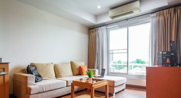 Deluxe Condo | Living area | 55-inch TV with cable channels