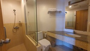 A bathroom with a glass-enclosed shower, a toilet, a sink, and a mirror. - Lake Side Condominium (Khon Kaen)