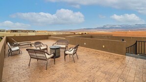 Eine Dachterrasse mit Korbmöbeln und Bergblick.
