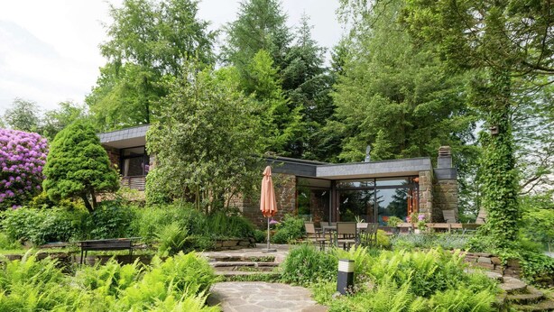 Una casa moderna con un sendero de piedra que conduce a un porche cubierto.