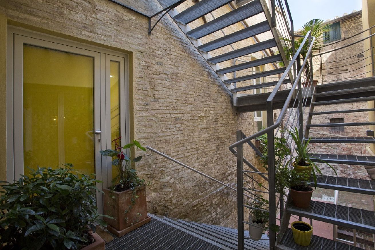 Un escalier avec des rampes en métal et des plantes en pot.