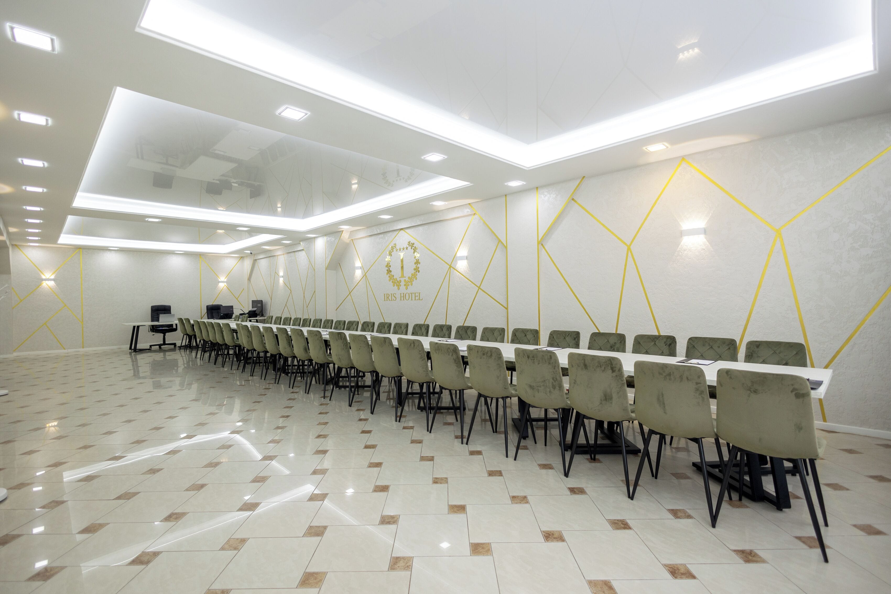 A conference room with a long table, chairs, and a geometric wall design.