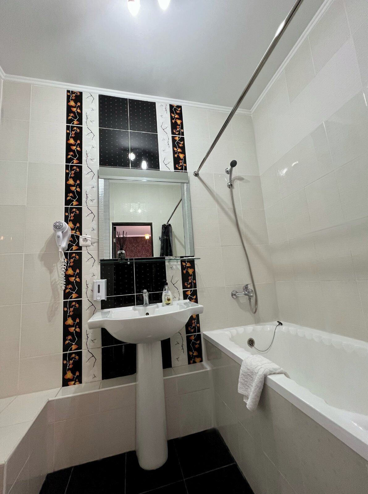 Un baño con lavamanos blanco, bañera y ducha.