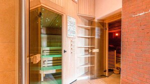 A hotel room with a wooden door, a green bench, and a brick wall. - Junior suite castle lakeside - Seehotel Schloss Klink (Klink)