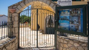 A traditional stone gate with a sign for Skandalis, a traditional suite hotel. - Skandalis Apartments with sea & pool view (Klio) (CHORAFAKIA CHANIA)