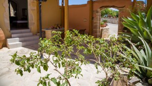 A patio area with a pergola, stone flooring, and potted plants. - Skandalis Apartments with sea & pool view (Klio) (CHORAFAKIA CHANIA)